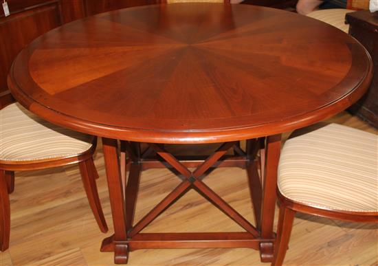 A 20th century French cherrywood radially extending dining table, the circular table extends to 6ft 7in.